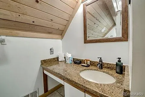 a bathroom with a granite countertop sink and a mirror