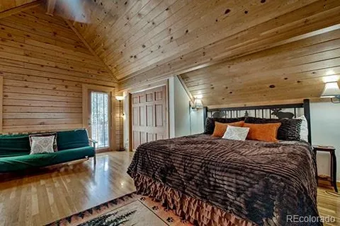 a large bed sitting in a bedroom next to a window