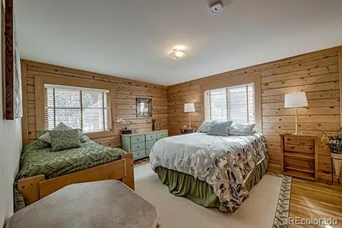 a bedroom with a bed and dresser with mirror