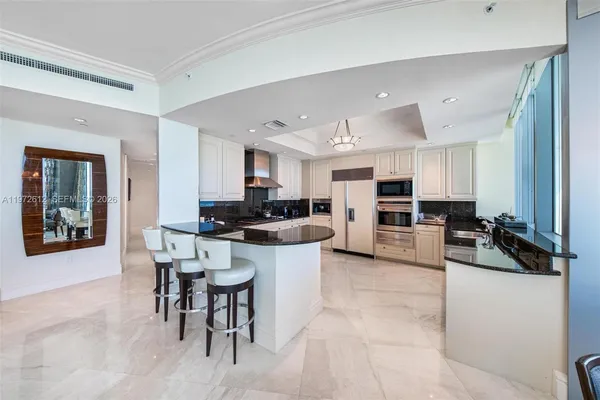 a kitchen with stainless steel appliances kitchen island granite countertop a sink and cabinets