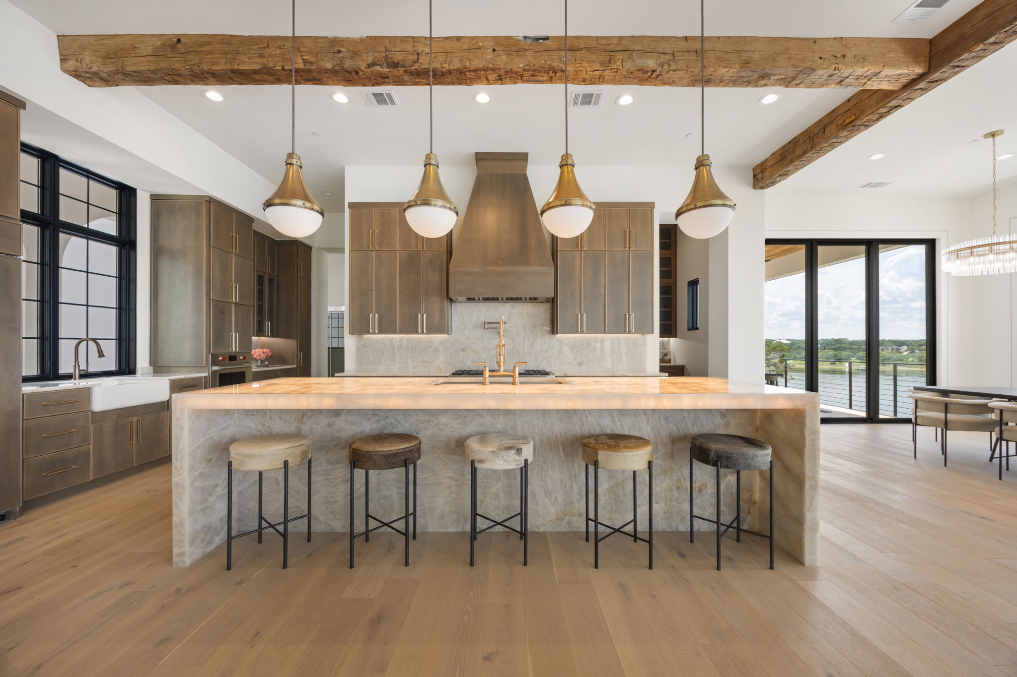 1496 Buffalo Gap Road Lakeway, TX 78734 - Photo 7 of 37 Chef's kitchen with illuminated island seating, rich wooden beams, and views to the waterfront.