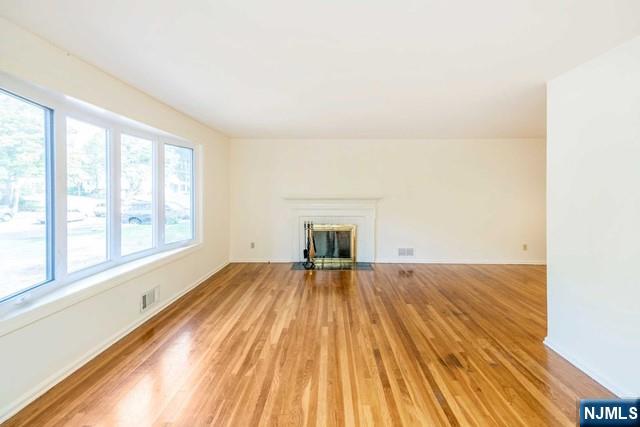 10 Gwynne Court Closter, NJ 07624 - Photo 4 of 22 a view of an empty room with wooden floor and a window
