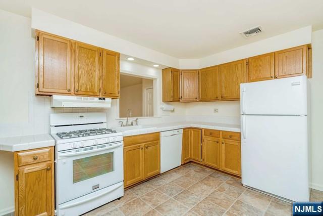 10 Gwynne Court Closter, NJ 07624 - Photo 9 of 22 a kitchen with a refrigerator sink stove and cabinets