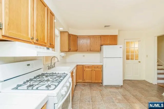 a kitchen with cabinets a refrigerator and a sink