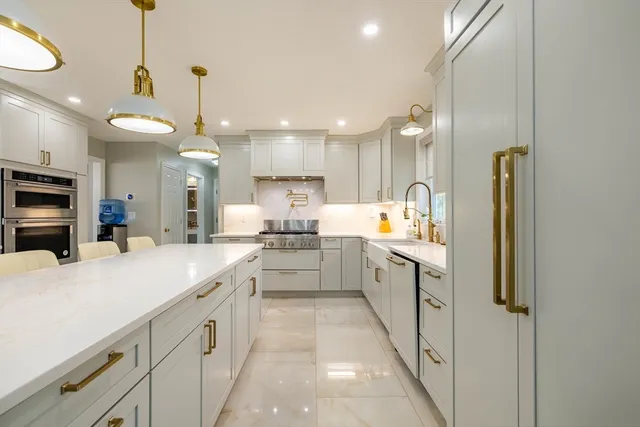 a large kitchen with a large counter top appliances and cabinets