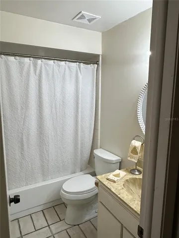 a bathroom with a granite countertop sink toilet and a mirror