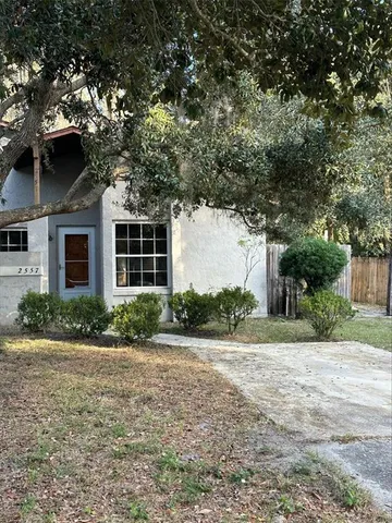 a front view of a house with a yard and potted plants
