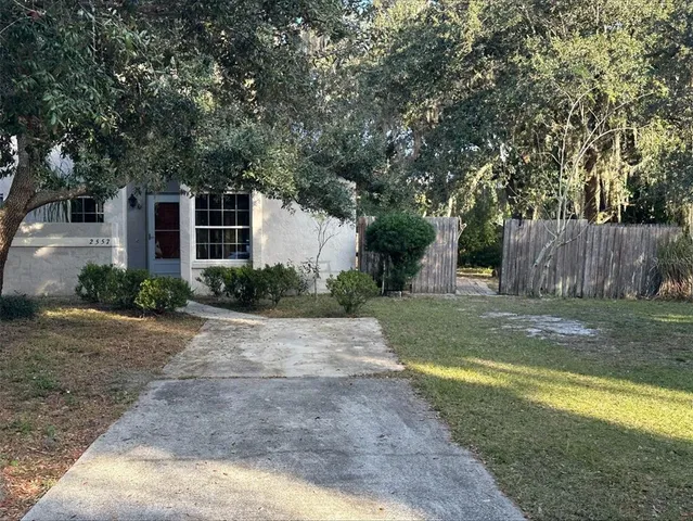 a view of a house with backyard and a tree