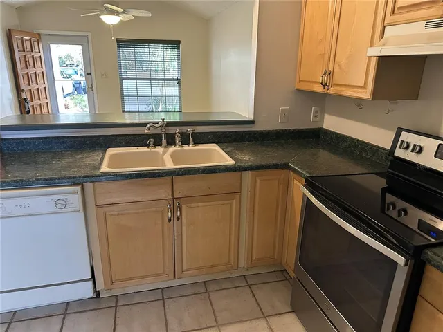 a kitchen with granite countertop a sink and a stove
