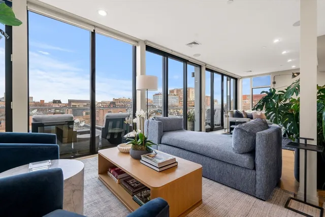 a living room with furniture and a floor to ceiling window