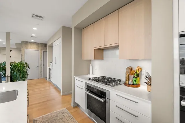 a kitchen with white cabinets and appliances