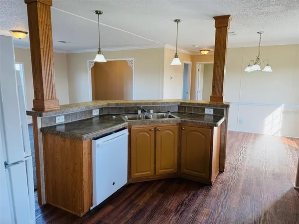 a kitchen with stainless steel appliances granite countertop a stove a sink a refrigerator and wooden floor