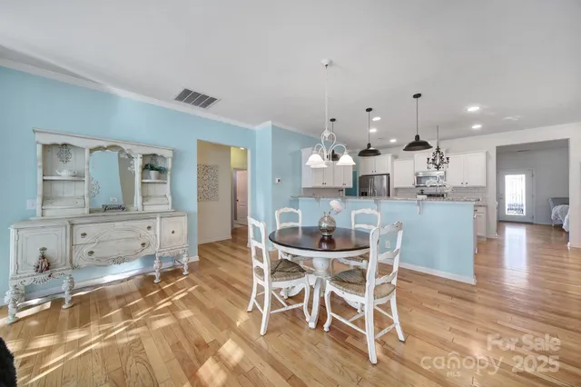 a dining room with kitchen island stainless steel appliances furniture a dining table and chairs