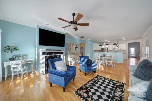 a living room with furniture and a flat screen tv with kitchen view