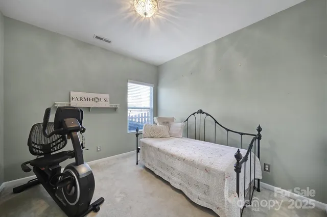 a bedroom with a bed a chandelier and a window