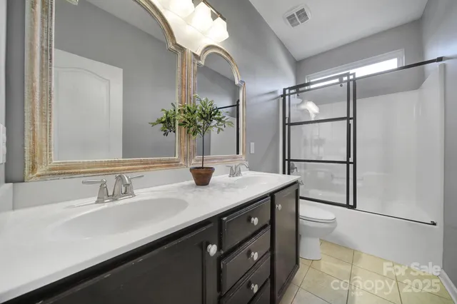 a bathroom with a granite countertop sink a mirror and shower