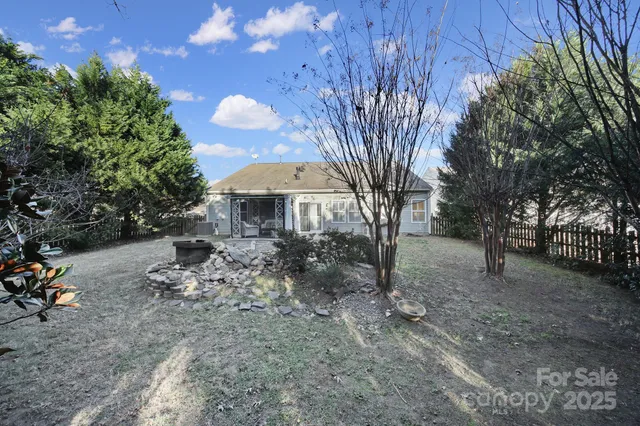 a backyard of a house with table and chairs under an umbrella
