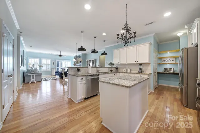 a kitchen with stove a refrigerator and a view of living room