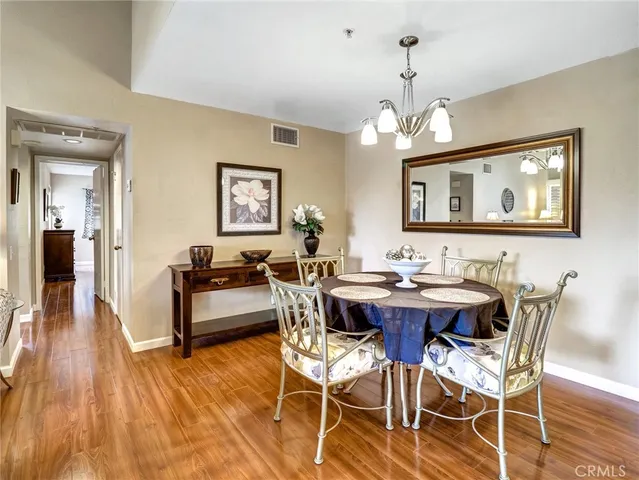 a view of a dining room with furniture wooden floor and chandelier