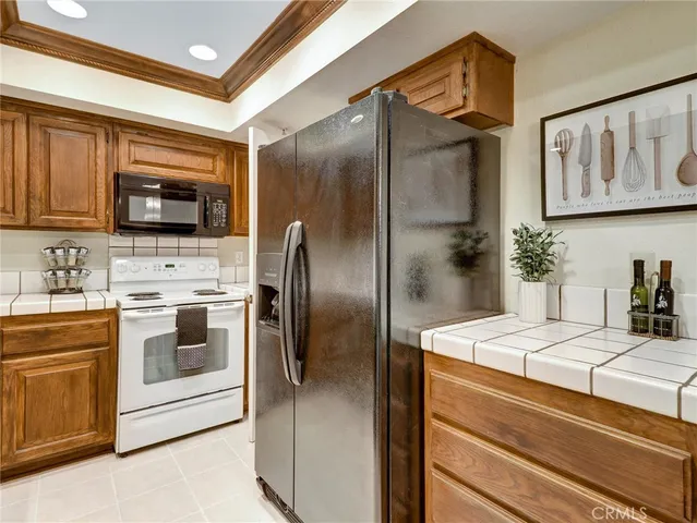 a kitchen with stainless steel appliances kitchen island a refrigerator sink and microwave