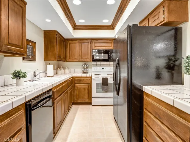 a kitchen with stainless steel appliances granite countertop a sink a stove and a refrigerator