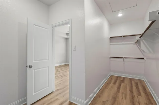 a view of walk in closet with wooden floor
