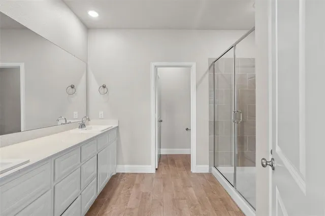 a bathroom with a double vanity sink a mirror and a shower