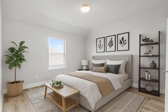 a bedroom with bed and a potted plant