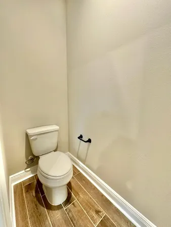a white toilet sitting next to a white wall