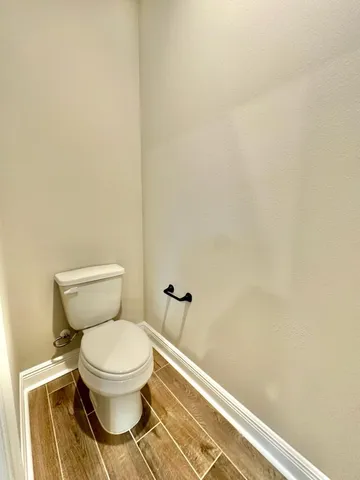 a white toilet sitting next to a white wall
