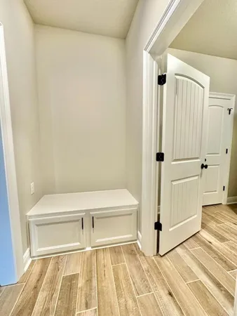 a view of a room with wooden floor and white walls