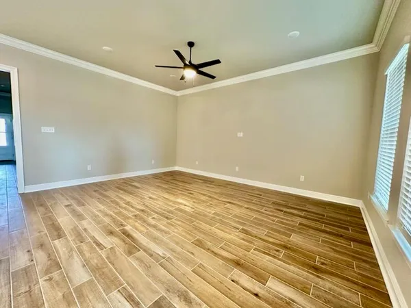 a view of a big room with wooden floor and windows in a room