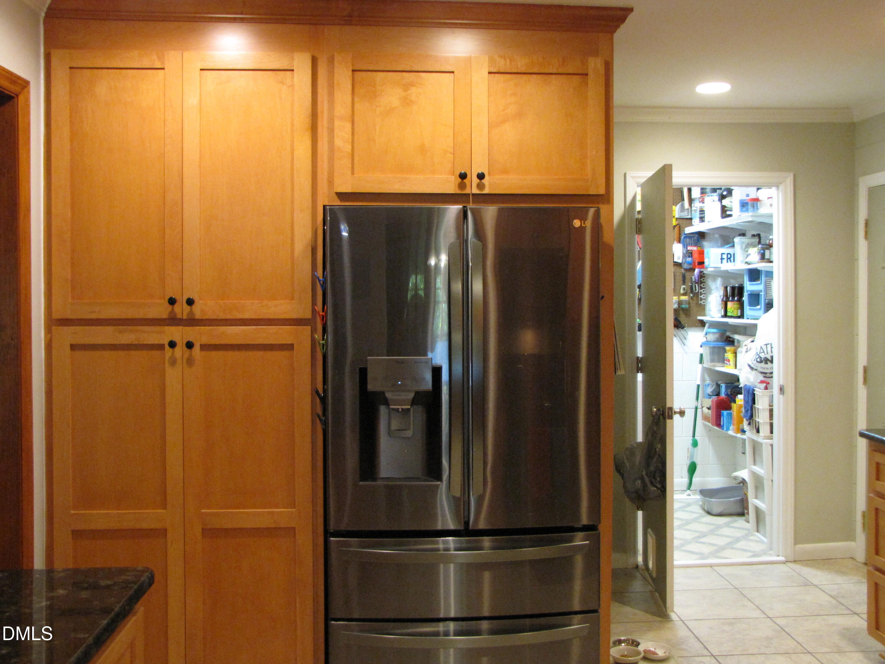 2907 Elgin Street Durham, NC 27704 - Photo 8 of 19 a view of a refrigerator in kitchen and an empty room with wooden floor