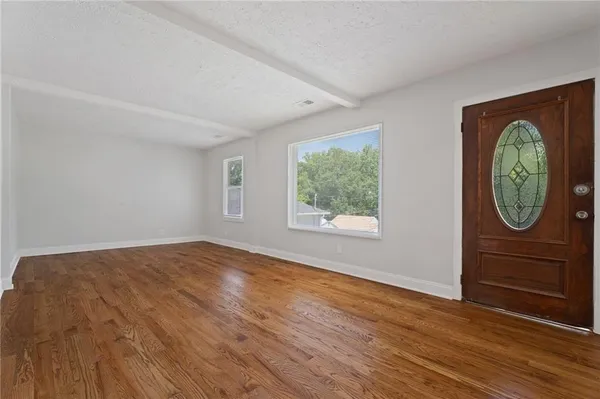 an empty room with window and mirror