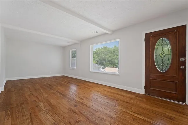 an empty room with window and mirror