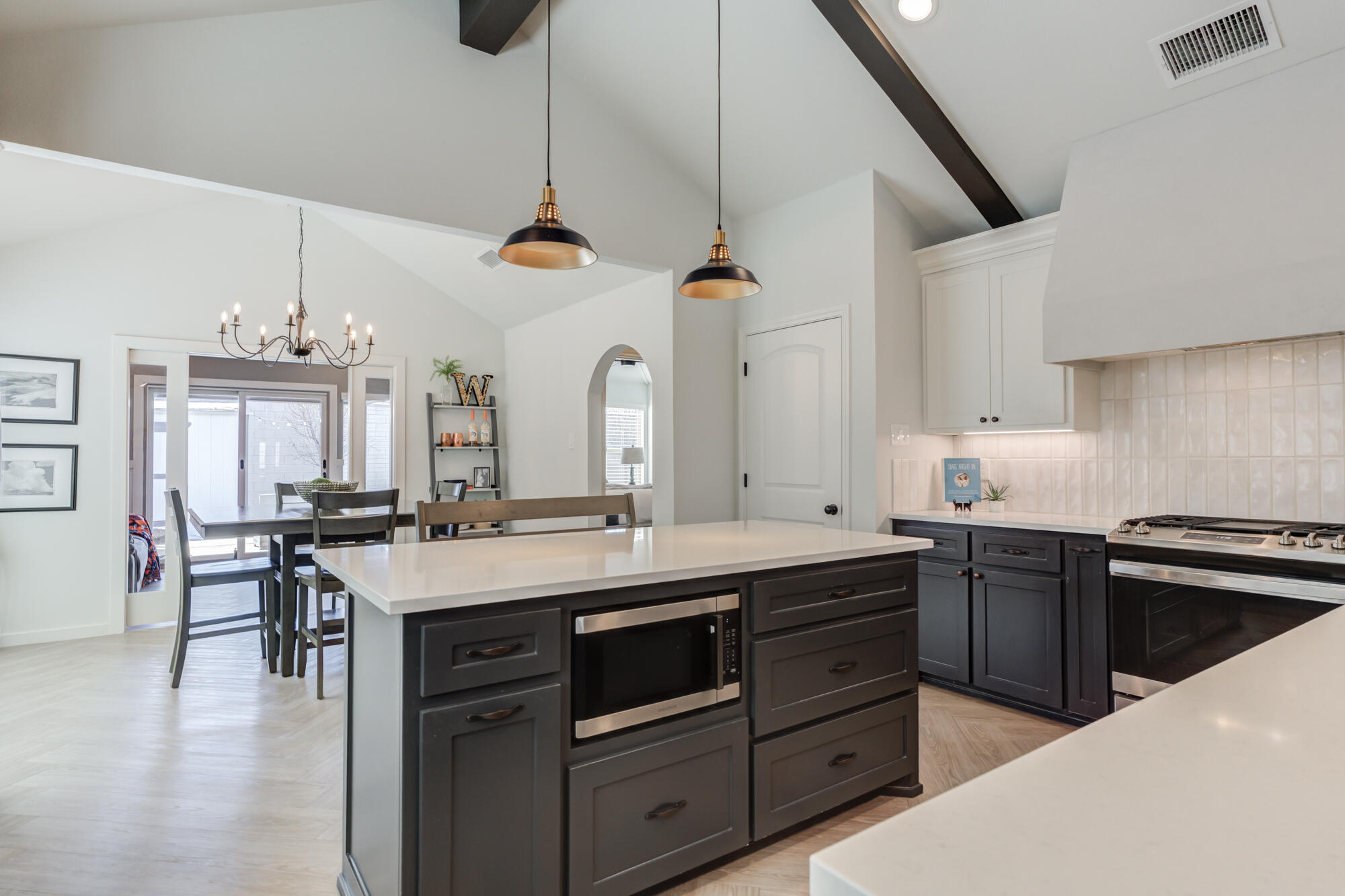 3627 128th Street Lubbock, TX 79423 - Photo 19 of 60 a kitchen with a stove a sink a dining table and chairs