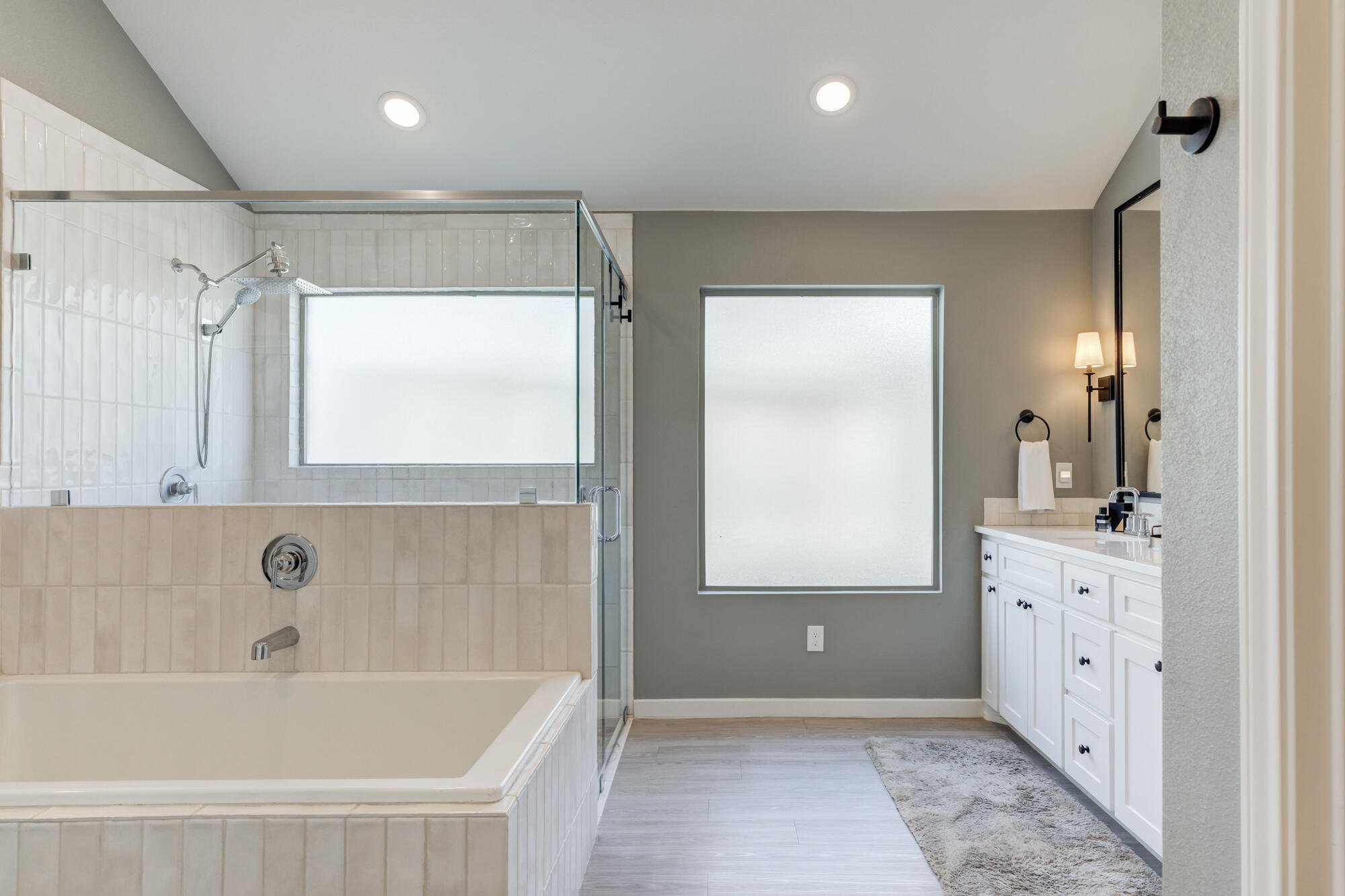 3627 128th Street Lubbock, TX 79423 - Photo 31 of 60 a bathroom with a bathtub a mirror a vanity and a shower