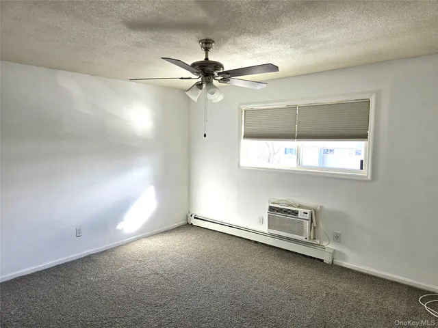 en empty room with windows and ceiling fan