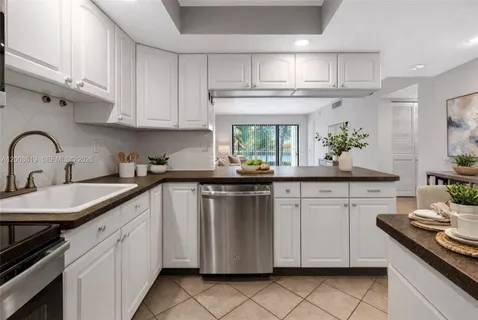 a kitchen with granite countertop white cabinets and white appliances