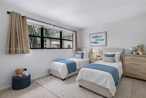 a bedroom with two beds and a potted plant