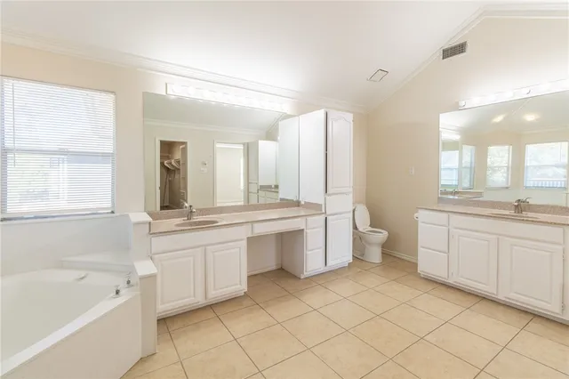 a large bathroom with a double vanity sink a mirror and a bathtub