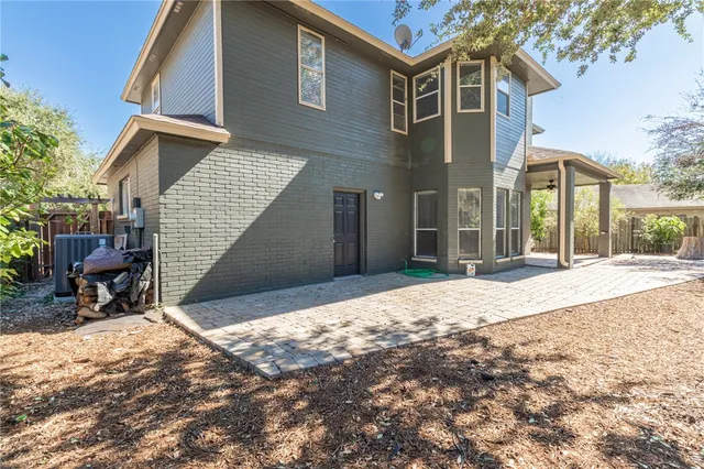 a backyard of a house with a bench and trees