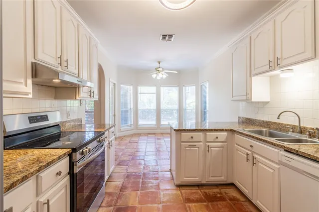 a kitchen with a sink stove and cabinets