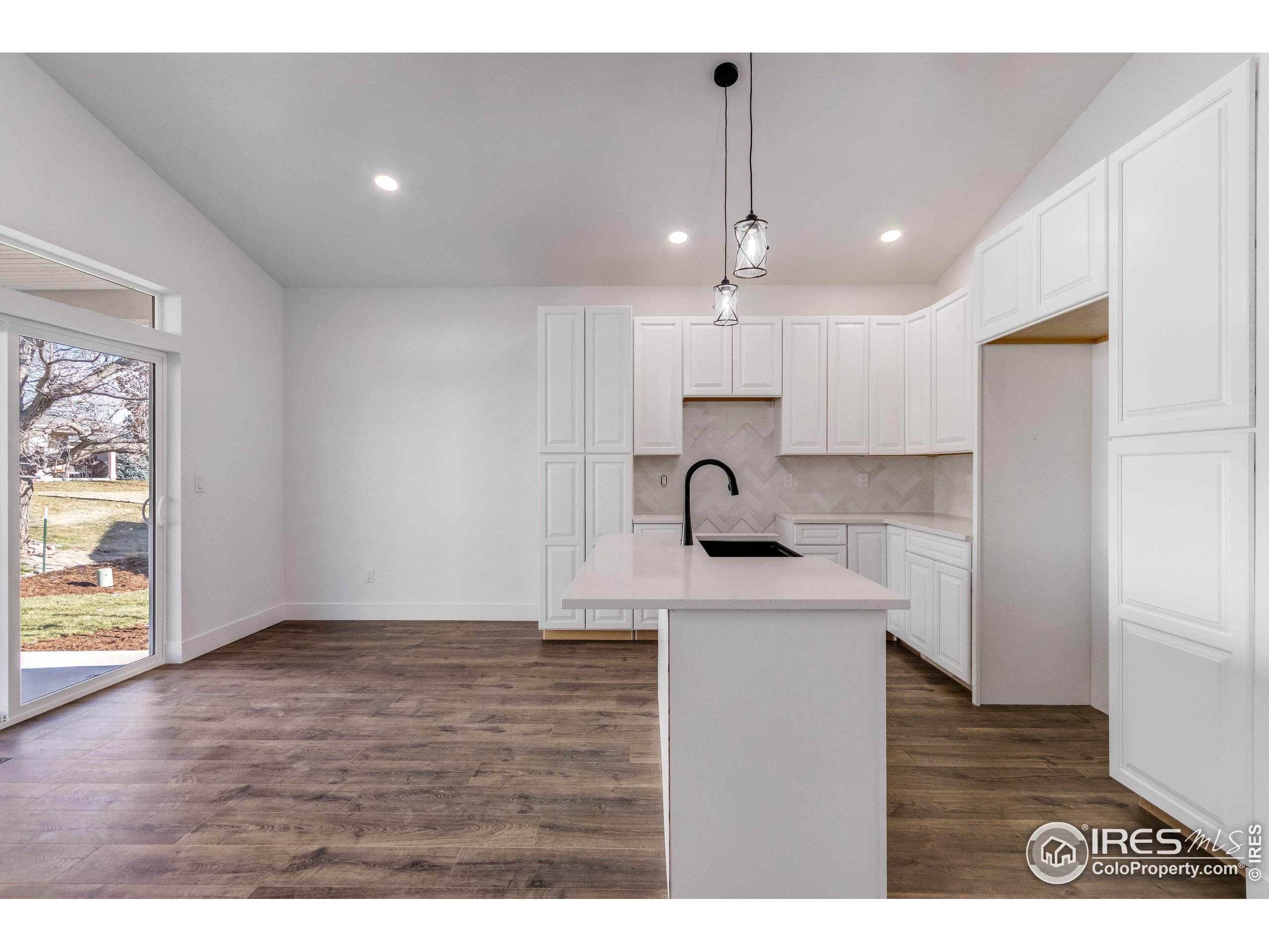 1230 Swainson Road Eaton, CO 80615 - Photo 14 of 35 a kitchen with kitchen island a sink stainless steel appliances and cabinets