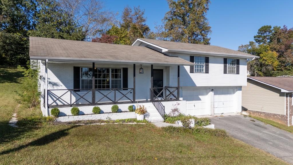 1717 East Rebel Road Rossville, GA 30741 - Photo 27 of 36 a view of a white house with large windows and a small yard