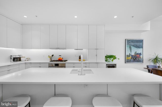 a kitchen with a sink a toilet and cabinets