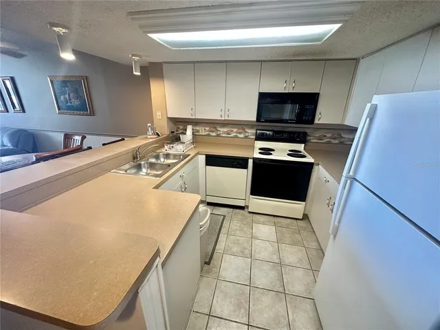 a kitchen with stainless steel appliances a stove a sink and a refrigerator