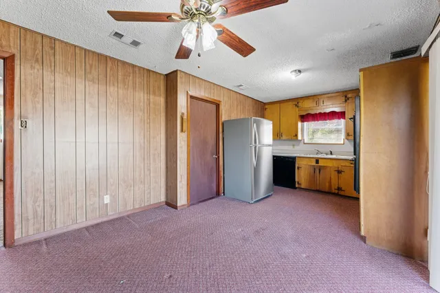 a view of a kitchen with refrigerator and a ceiling fan