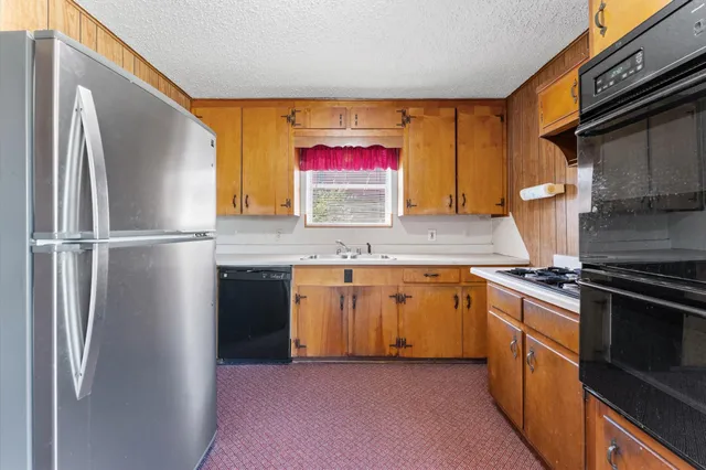 a kitchen with stainless steel appliances granite countertop a refrigerator and a sink