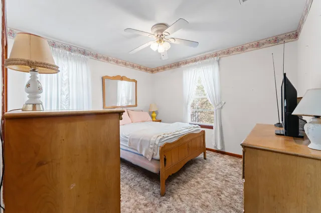 a bedroom with a bed window and a flat screen tv